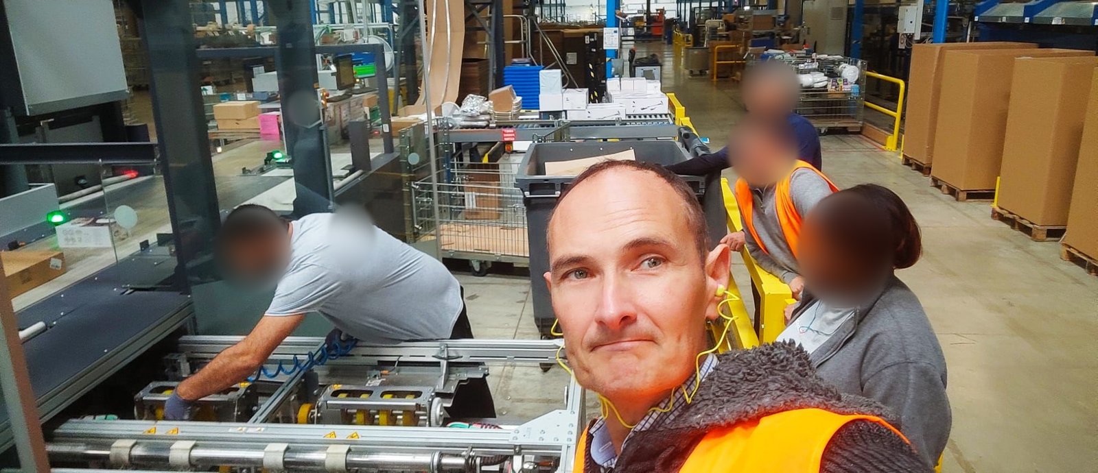 Charles Bourinet en gemba dans un entrepôt, observant avec une équipe le travail d'un opérateur